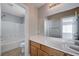 Bright bathroom featuring a shower-tub combo, and a large mirror over a wooden vanity at 9004 Snowtrack Ave, Las Vegas, NV 89149