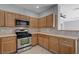 Well-lit kitchen features stainless steel appliances, tile countertops, and wood cabinetry at 9004 Snowtrack Ave, Las Vegas, NV 89149