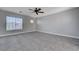 Bright living room features carpeting, a ceiling fan, and abundant natural light from the large window at 9004 Snowtrack Ave, Las Vegas, NV 89149