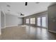 Spacious, open-concept living room featuring tile floors and a stylish ceiling fan and access to the patio at 9004 Snowtrack Ave, Las Vegas, NV 89149