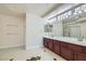 This bathroom features double sinks, a large vanity, and tile floors at 9208 November Breeze St, Las Vegas, NV 89123