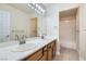 Bright bathroom featuring double sinks, large mirror, and tiled floors at 9208 November Breeze St, Las Vegas, NV 89123