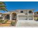 Charming two-story home with stucco exterior, tiled roof, three-car garage, and manicured front yard at 9208 November Breeze St, Las Vegas, NV 89123