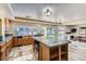 Bright kitchen features wood cabinets, island with granite counters, stainless steel appliances, and access to backyard at 9208 November Breeze St, Las Vegas, NV 89123