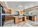 Bright kitchen features wood cabinets, island with granite counters, stainless steel appliances, and gorgeous tile flooring at 9208 November Breeze St, Las Vegas, NV 89123