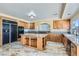 Bright kitchen features wood cabinets, island with granite counters, stainless steel appliances, and gorgeous tile flooring at 9208 November Breeze St, Las Vegas, NV 89123