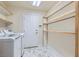 Well-lit laundry room with marble floors, shelving, and a white entry door at 9208 November Breeze St, Las Vegas, NV 89123
