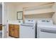 Bright laundry room featuring modern washer and dryer, sink, and built-in shelving at 9208 November Breeze St, Las Vegas, NV 89123