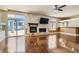 Open living room features a stone fireplace, backyard access, and wood floors at 9208 November Breeze St, Las Vegas, NV 89123