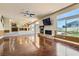 Open living room features a stone fireplace, backyard access, wet bar, and wood floors at 9208 November Breeze St, Las Vegas, NV 89123