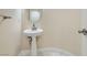 This powder room has a pedestal sink, round mirror and marble floors at 9208 November Breeze St, Las Vegas, NV 89123