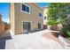 Paver patio, minimal landscaping, and tan stucco exterior of a two story home under a blue sky at 9450 Niagara Landing St, Las Vegas, NV 89139