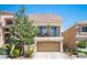 Charming two-story home with a balcony, two-car garage, and desert landscaping under a clear blue sky at 9450 Niagara Landing St, Las Vegas, NV 89139
