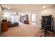 Spacious carpeted living room with ceiling fan, entertainment center, and access to the bedroom at 9450 Niagara Landing St, Las Vegas, NV 89139