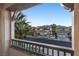 Balcony view showcasing serene street with beautiful homes, mature palms, and mountain views at , Las Vegas, NV 89135