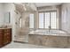 Bathroom featuring a glass enclosed shower, soaking tub, and travertine tile at , Las Vegas, NV 89135