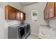 Convenient laundry room equipped with modern washer and dryer units, complemented by custom cabinetry and sink at , Las Vegas, NV 89135