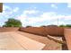 A spacious backyard with partial patio and decorative perimeter wall for gardening or other outdoor enjoyment at 100 Samantha Rose St, Henderson, NV 89012