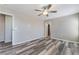Bedroom with gray wood-look floors, ceiling fan, and open door at 100 Samantha Rose St, Henderson, NV 89012