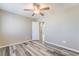A simple bedroom with wood-look flooring, neutral-color walls and trim, and an open door at 100 Samantha Rose St, Henderson, NV 89012