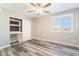 This bedroom features wood-look floors, a ceiling fan, a window, and a closet with built-ins at 100 Samantha Rose St, Henderson, NV 89012