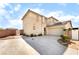 This home features a front-facing two-car garage and a low-maintenance desert landscape at 100 Samantha Rose St, Henderson, NV 89012