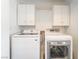A dedicated laundry area features a washer, dryer, and white cabinets for convenient storage at 100 Samantha Rose St, Henderson, NV 89012