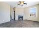 Living room area with stylish ceiling fan, large window, and cozy fireplace feature at 100 Samantha Rose St, Henderson, NV 89012
