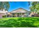 Home features an outdoor patio, artificial turf lawn, and mature trees at 10213 Treasure Mountain Ct, Las Vegas, NV 89129