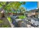 Backyard with lush artificial grass, mature trees, a playhouse, and an outdoor kitchen area at 10213 Treasure Mountain Ct, Las Vegas, NV 89129
