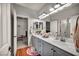 Bathroom with double sinks and cabinets, mirrors and a view into the bedrooms at 10213 Treasure Mountain Ct, Las Vegas, NV 89129