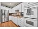 Modern kitchen featuring stainless steel appliances, white cabinets, and sleek countertops at 10213 Treasure Mountain Ct, Las Vegas, NV 89129
