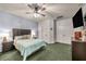 Spacious main bedroom features a ceiling fan, TV, a blue accent wall, and green carpet at 10213 Treasure Mountain Ct, Las Vegas, NV 89129