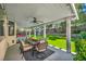 Covered patio with ceiling fan and outdoor dining set, overlooking the lush, artificial turf backyard at 10213 Treasure Mountain Ct, Las Vegas, NV 89129