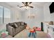 Bright playroom features a large window, comfortable seating, and a ceiling fan at 10213 Treasure Mountain Ct, Las Vegas, NV 89129