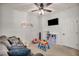 Cozy playroom features a ceiling fan, plush seating, wall-mounted TV and bright storage at 10213 Treasure Mountain Ct, Las Vegas, NV 89129