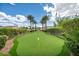Beautiful putting green with manicured landscaping and mature trees, offering a recreational space within the community at 10213 Treasure Mountain Ct, Las Vegas, NV 89129