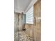 Shower featuring marble-style walls, glass block window, and a stone pebble floor at 10213 Treasure Mountain Ct, Las Vegas, NV 89129