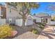Cozy home backyard featuring desert landscaping, a shade tree, and white privacy fencing at 1030 Tam O Shanter, Las Vegas, NV 89109
