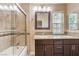 Bathroom featuring double sinks, granite countertops and shower with glass door at 1030 Tam O Shanter, Las Vegas, NV 89109
