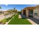 Manicured backyard featuring artificial turf, gravel, and a walkway to the covered patio area of the house at 10372 Premia Pl, Las Vegas, NV 89135