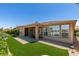 Backyard with artificial turf, desert landscaping, and a covered patio area, offering a serene outdoor space at 10372 Premia Pl, Las Vegas, NV 89135