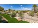 Backyard showcasing artificial turf, desert landscaping, and a view of the surrounding desert and homes at 10372 Premia Pl, Las Vegas, NV 89135