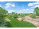 Landscaped backyard featuring artificial turf, rock features, and privacy fencing at 10372 Premia Pl, Las Vegas, NV 89135
