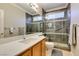 Modern bathroom with a glass shower, quartz countertops, and wood cabinets at 10372 Premia Pl, Las Vegas, NV 89135