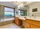 Bright bathroom features double sinks, a soaking tub, and a separate shower at 10372 Premia Pl, Las Vegas, NV 89135