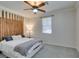 This bedroom features a unique wood accent wall, ceiling fan, and a cozy bed with soft blankets and pillows at 10372 Premia Pl, Las Vegas, NV 89135