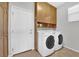 Functional laundry room with washer, dryer, cabinets, and ample storage space at 10372 Premia Pl, Las Vegas, NV 89135