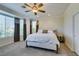 Bright main bedroom with ceiling fan, large windows, and plush carpet offering a serene retreat at 10372 Premia Pl, Las Vegas, NV 89135