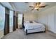 Cozy main bedroom with ceiling fan, large window, and plush carpet providing comfort at 10372 Premia Pl, Las Vegas, NV 89135